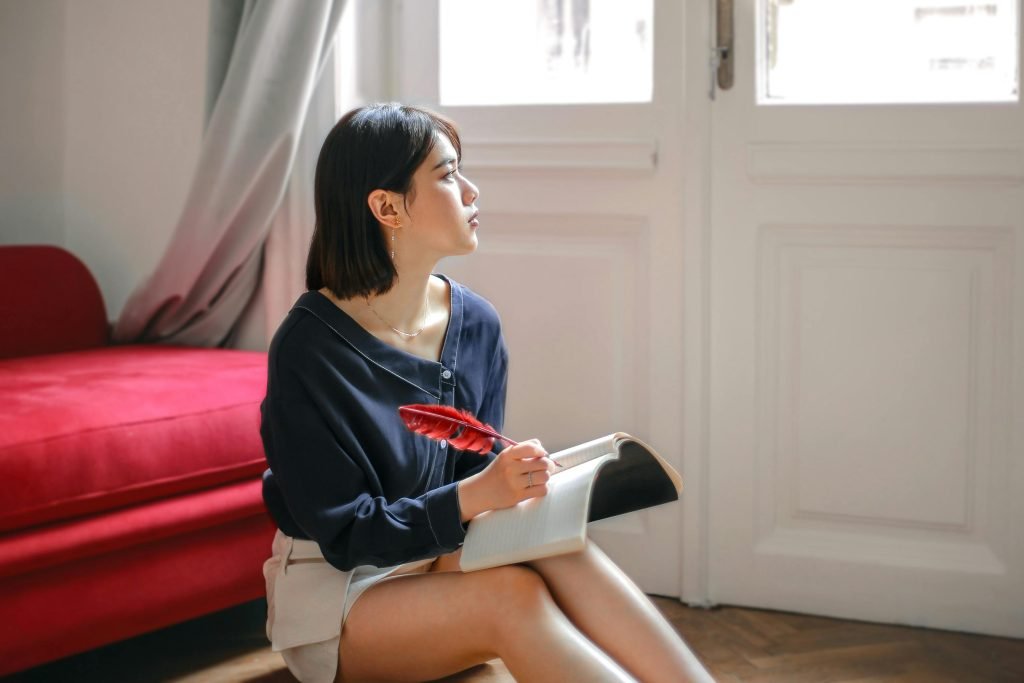 Image of a woman writing in a success journal - illustration for negative self-talk article.