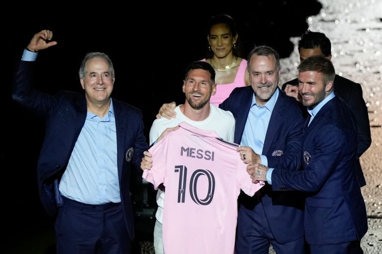 Lionel Messi showcases his jersey during a presentation event with Inter Miami's co-owners