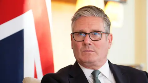 A portrait of Keir Starmer with a Union Jack background.