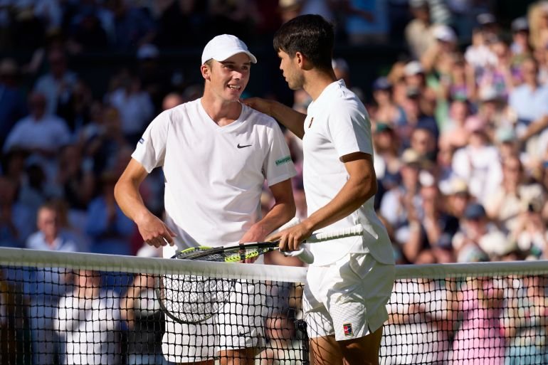 Oliver Tarvet at the net with Carlos Alcaraz during their match