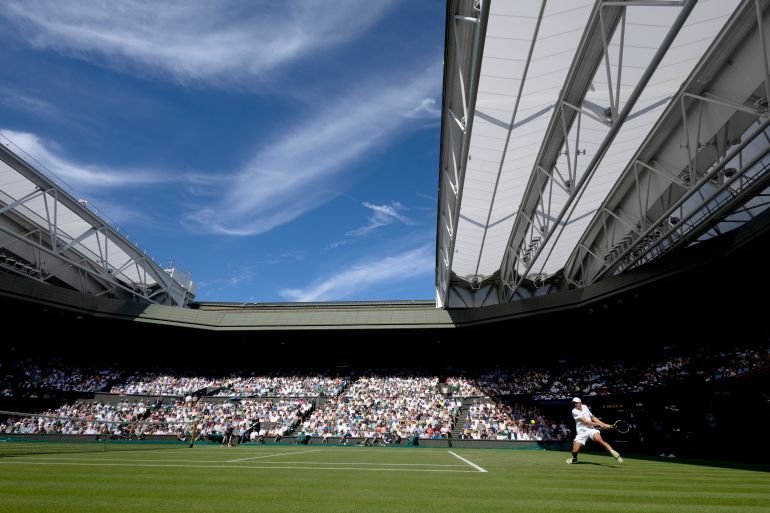 Action shot of Oliver Tarvet against Carlos Alcaraz in Wimbledon 2025