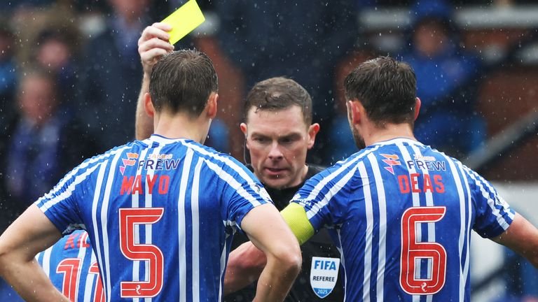 KILMARNOCK, SCOTLAND - September 14, 2025: Referee John Beaton shows a yellow card to Lewis Mayo of Kilmarnock during a match against Celtic at Rugby Park.