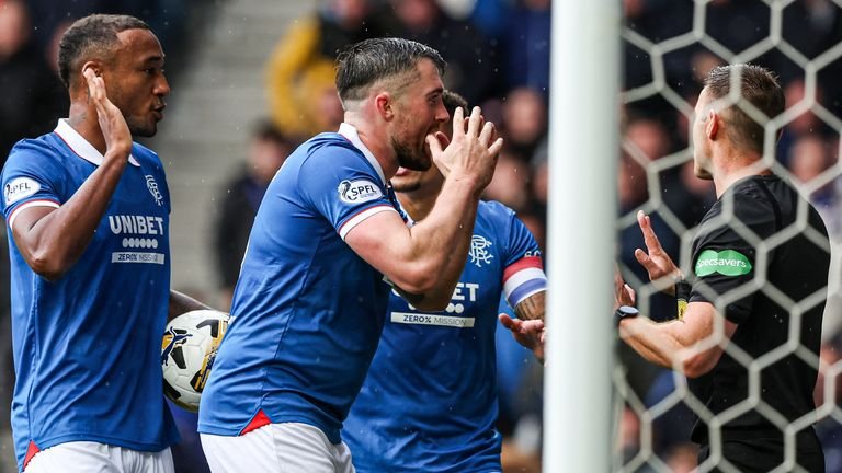 GLASGOW, SCOTLAND - September 13, 2025: Derek Cornelius and John Souttar from Rangers question referee Steven McLean after their goal was disallowed due to a foul on Alexander Schwolow from Hearts during a William Hill Premiership match at Ibrox Stadium.